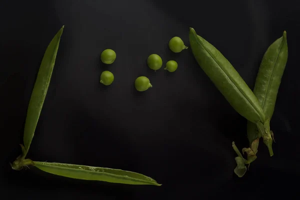 黒い背景のエンドウ豆の鞘 暗い背景のポッドの緑のエンドウ豆 — ストック写真