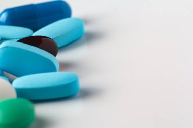 Hafif arka planda çeşitli haplar, vitaminler ve ilaçlar.