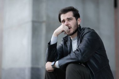 Morali bozuk bir adam yere kapanıp secde eder gibi bakar..