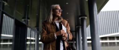 Gözlüklü bir iş kadını işe dizüstü bilgisayarla gidiyor..