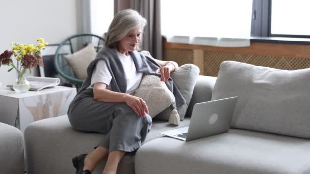 整洁的女人通过笔记本电脑与孙子孙女交流 并在家里工作 — 图库视频影像