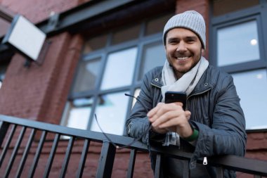 Dışarıda elinde cep telefonu olan güçlü bir karizma..