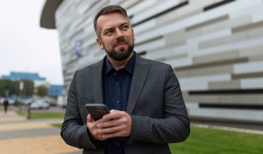 Prezentabl erkek işadamı dışarıda telefon tutuyor..