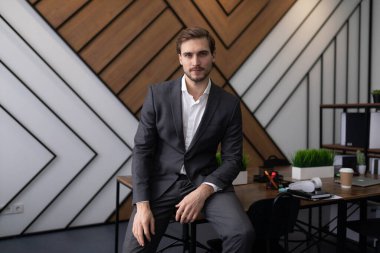 Erkek avukat ofiste masanın üstünde oturur ve kameraya bakar..