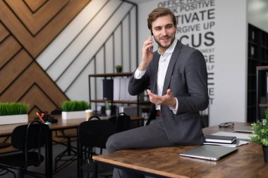 Oldukça başarılı bir işadamı ofiste telefonla konuşuyor..