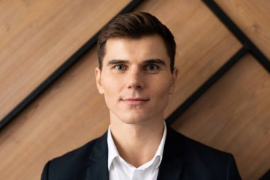 Moda bir ofiste duran genç işadamının portresi.