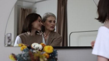 Anne ve kızı aynaya bakarken birbirlerine sokuluyorlar..