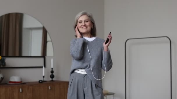 Vuxen Gråhårig Snygg Kvinna Dansar Med Telefon Händerna Och Hörlurar — Stockvideo