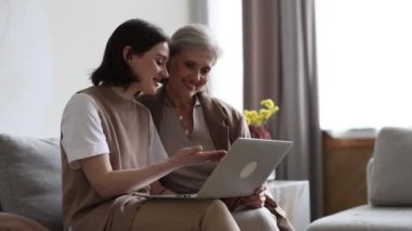 Yetişkin bir kız çocuğu yaşlı gri saçlı bir anneye modern aletleri nasıl kullanacağını ve dizüstü bilgisayarla nasıl çalışacağını anlatıyor..