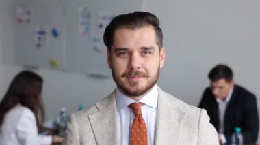 Ofisteki iş arkadaşlarının geçmişiyle eşleşen takım elbiseli orta yaşlı bir yönetici..