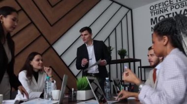 Ofisteki büyük bir masadaki meslektaşlar iş geliştirme planlarını tartıştılar.