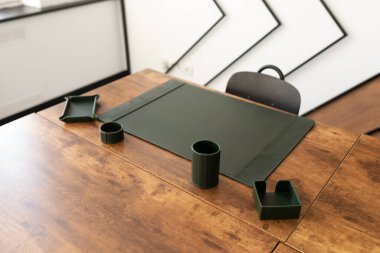 Ofiste deri yeşil kırtasiye aksesuarlarıyla boş bir işyeri var..