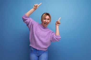 Sevimli, enerjik, hoş, sarışın, parlak bir arka planda suratını buruşturan genç bir kadın..