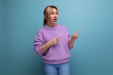 Şok olmuş sarışın bir kadının portresi. Sıradan bir bakışla elini parlak bir arkaplanda fotokopi aletiyle gösteriyor..