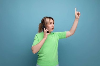 Yoğun, çekici, sarışın bir kız telefonda konuşuyor. Fotokopi çekilen mavi bir arka planda sessiz olmak istiyor..