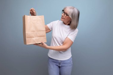 Stüdyo geçmişinde sosyal paket taşıyan orta yaşlı bir kadın..