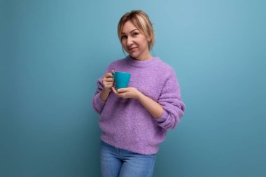 Neşeli sarışın, genç bir milenyum kadını, sıradan görünüşlü, parlak bir arka planda bir fincan kahveyle fotokopi alanı olan..