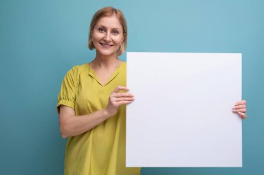 Bilgi için orta yaşlı bir kadın poster modeli tutuyor.