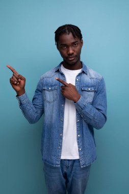 Karizmatik stil sahibi siyahi Afrikalı adam parmağıyla kenarı gösteriyor..