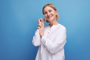 Enerjik, sağlıklı, orta yaşlı, sarı saçlı bir kadın..