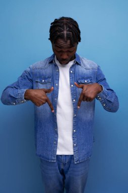 Karizmatik stil sahibi siyahi Afrikalı adam parmağıyla kenarı gösteriyor..