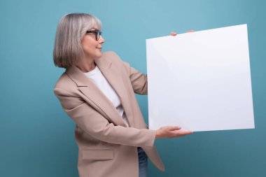 Yakın plan, ceketli olgun bir kadın fotokopi alanı ile parlak bir arkaplan üzerinde mocap şablonu gösterir.