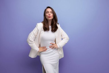 Moda sektörü beyaz elbiseli genç bayan stüdyo arka planında poz.