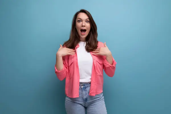 surprised young lady in shirt and jeans with open mouth on studio isolated background.