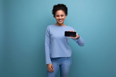 Genç esmer esmer tenli kadın web sayfası için akıllı telefonu yatay olarak tutuyor..