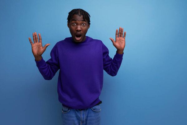 удивленный американский молодой человек с дредами в студии.