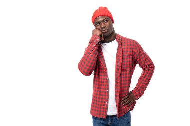 Şapkalı ve gömlekli genç Afrikalı adam, izole edilmiş beyaz arka plandan üzüntü içinde bildiriyor..