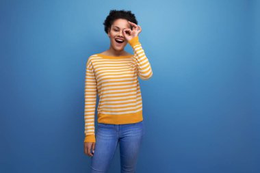 Afro saçlı, neşeli, iyimser, genç bir kadın..