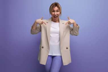 Arkaplanda fotokopi alanı ile başarılı bir şekilde çalışan ceketli, gülümseyen sarışın iş kadınının pozitifliği..