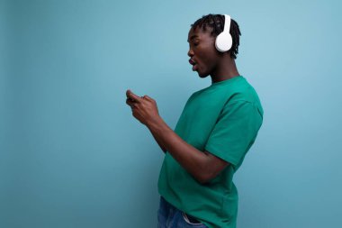 Genç Afrikalı adam kablosuz kulaklık ve cep telefonuyla oyun oynuyor..