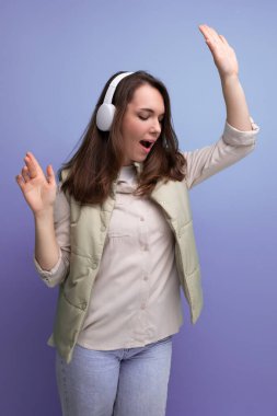 enerjik genç esmer kadın müzik dinliyor kulaklık ve cep telefonu kullanıyor..