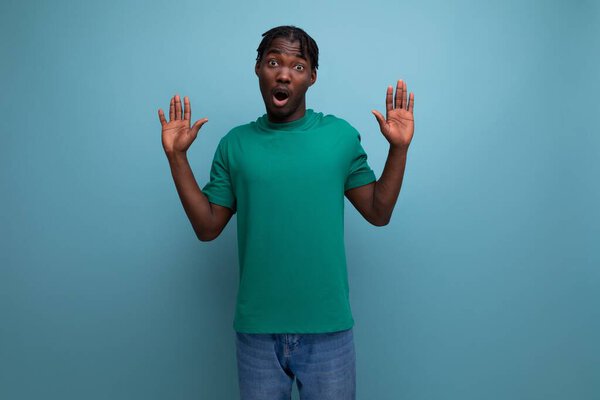 удивлена смущенная модель брюнетки стильный темнокожий мужчина в футболке на синем фоне.