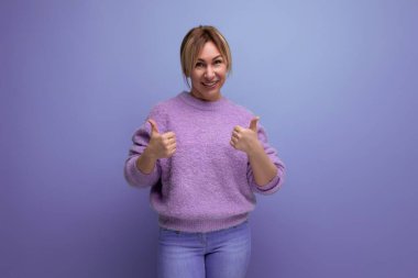 Mor arka planda fotokopi alanı olan sıradan bir süveter giyen sevimli, tatlı bir sarışının portresi..