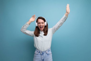 20 'li yaşlardaki esmer kadın, gayri resmi bir şekilde dinleniyor kulaklıkla müzik dinliyor..