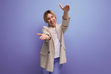 Sarı saçlı, ceketli 30 'lu yaşlarda bir kadın fotokopi stüdyosunun arka planına uzandı..