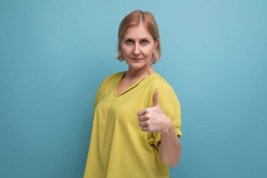 Sakin orta yaşlı kadın kamerayı işaret ediyor..