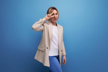 Beyaz ceketli, mavi arka planda fotokopi çeken sarışın bir kadın..