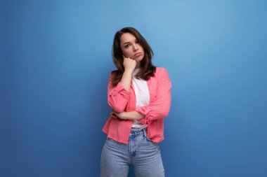 Uzun saçlı, esmer, günlük kıyafetli genç bir kadın izole edilmiş arka planda poz veriyor..