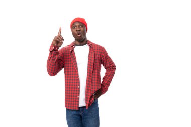 Şapkalı ve gömlekli genç Afrikalı bir adam, izole edilmiş beyaz arka plan üzerinden ilginç bir fikir aktarıyor..