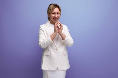 Güzel sarışın, kariyer sahibi, beyaz ceketli ve etekli, gülümseyen bir kadın..