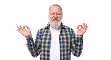 60 'lı yaşlarda, orta yaşlı, sakallı, beyaz arka planda neşeli mizaçlı, orta yaşlı bir adam..