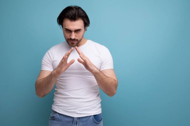 Beyaz tişörtlü genç esmer adam stüdyo arka planında dururken şöyle düşündü:.