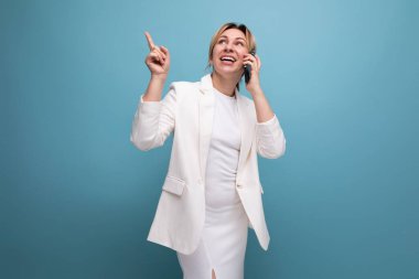 Oldukça bakımlı genç sarışın iş kadını telefonda konuşuyor..