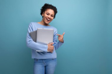 Dizüstü bilgisayarı ve elinde belgelerle başarılı bir afro esmer kız öğrenci..