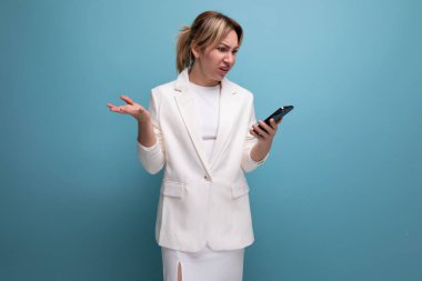 Zarif ceketli ve elbiseli zarif sarışın patron kadın akıllı telefon kullanıyor..