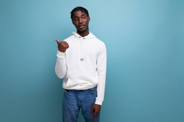Siyahi Amerikalı genç esmer adam parmağıyla duvarı işaret ediyor..